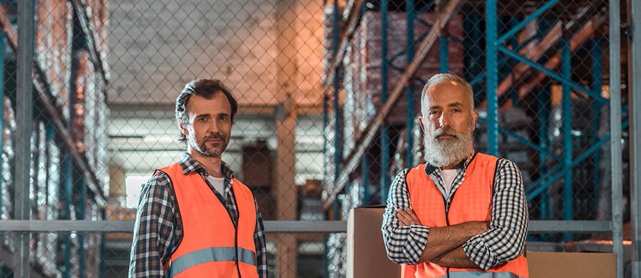 two confident male warehouse workers looking at camera